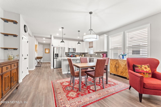 dining area featuring sink and light wood-type flooring