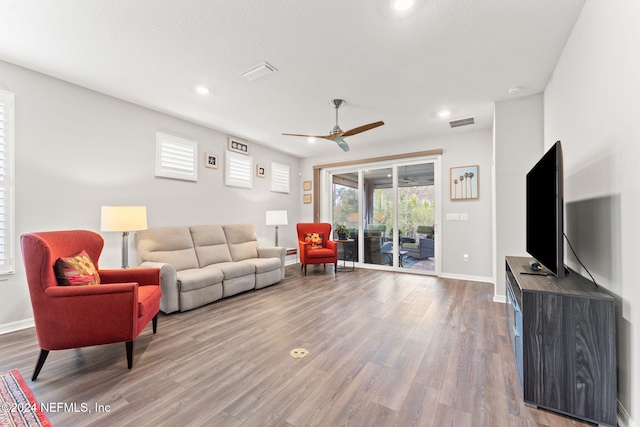 living room with wood-type flooring and ceiling fan