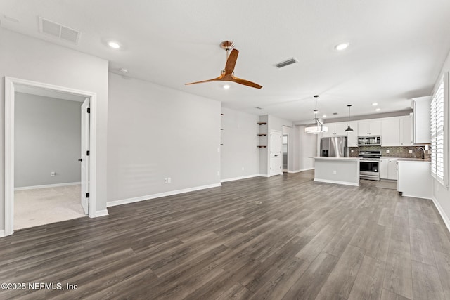 unfurnished living room featuring visible vents, recessed lighting, and dark wood-style floors