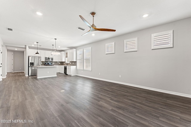 unfurnished living room with dark wood finished floors, baseboards, visible vents, recessed lighting, and ceiling fan