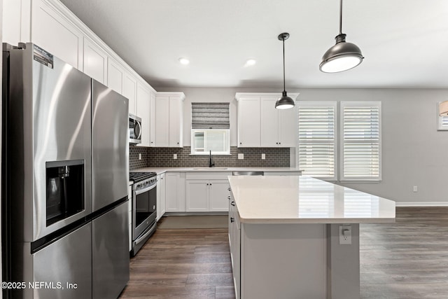 kitchen featuring a kitchen island, dark wood-style floors, stainless steel appliances, and a sink