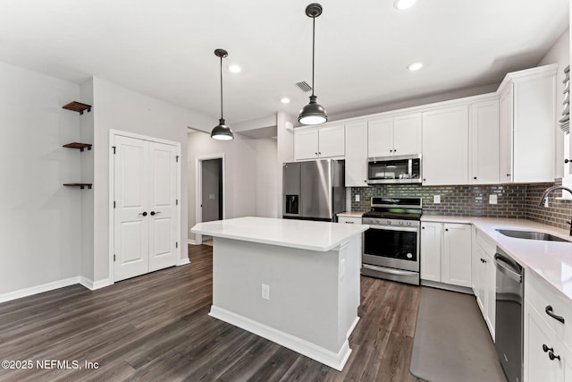 kitchen featuring dark wood finished floors, visible vents, a sink, a center island, and appliances with stainless steel finishes