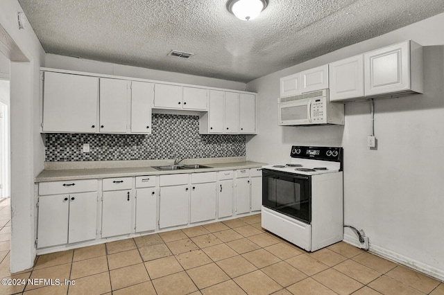 kitchen featuring decorative backsplash, white appliances, sink, light tile patterned floors, and white cabinets