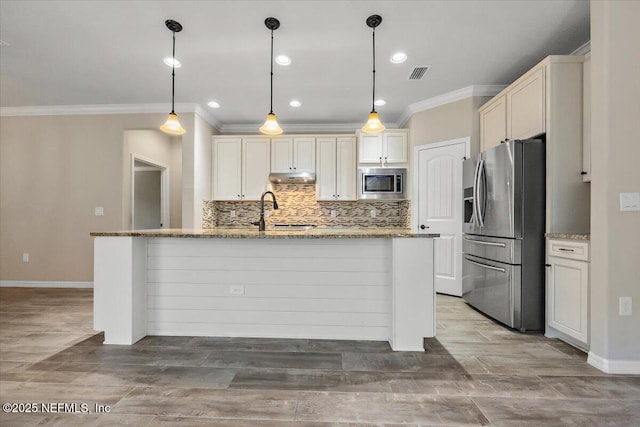 kitchen featuring light stone counters, appliances with stainless steel finishes, decorative light fixtures, and sink