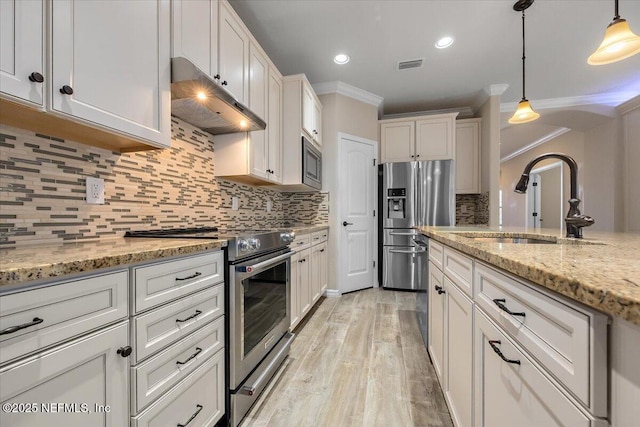 kitchen with sink, light stone counters, decorative light fixtures, stainless steel appliances, and white cabinets