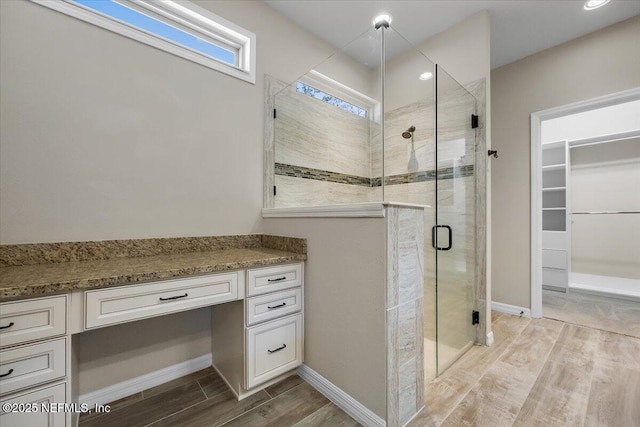 bathroom with a shower with door and vanity