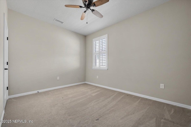 spare room with light carpet, ceiling fan, and a textured ceiling