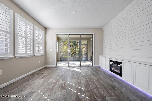 unfurnished living room with dark wood-type flooring and a textured ceiling