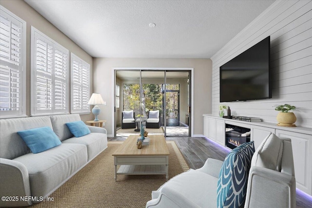 living room with a wealth of natural light, dark hardwood / wood-style floors, and a textured ceiling