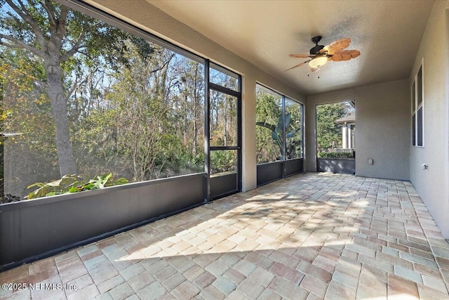 unfurnished sunroom with ceiling fan