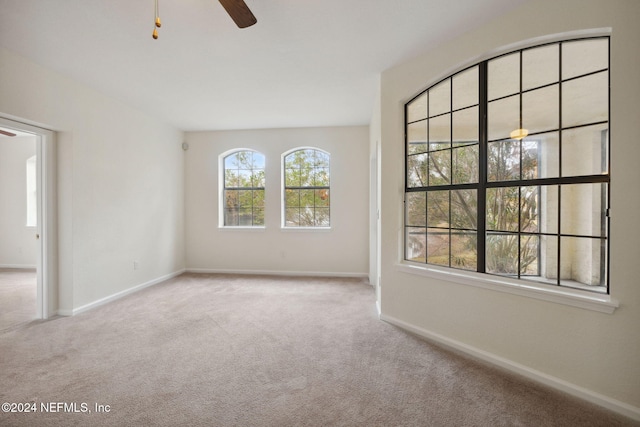 empty room with light colored carpet and ceiling fan