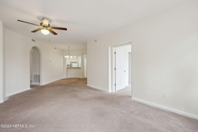 unfurnished room featuring light carpet and ceiling fan with notable chandelier