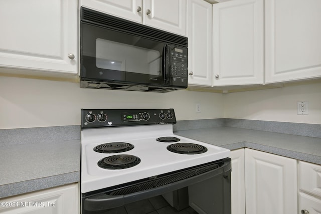 kitchen featuring white cabinetry, tile patterned flooring, and white electric range oven