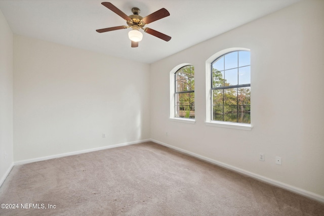 carpeted spare room featuring ceiling fan