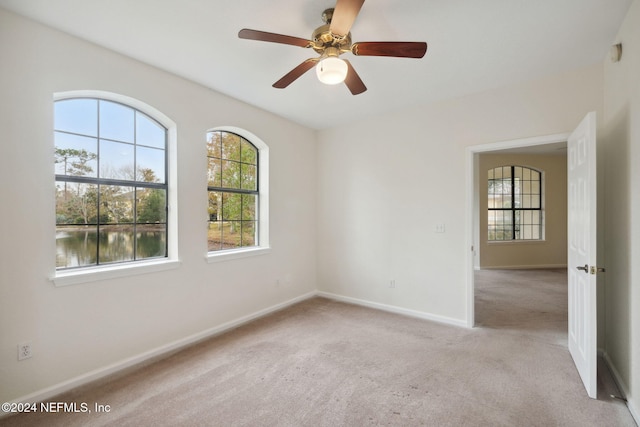 spare room featuring light carpet and ceiling fan