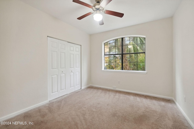 unfurnished bedroom with ceiling fan, a closet, and light colored carpet