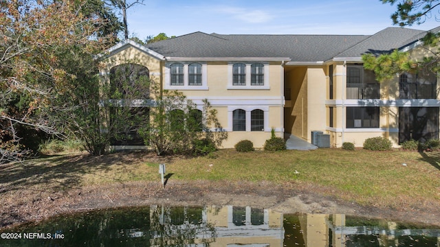 view of front of home with a front lawn and central AC unit