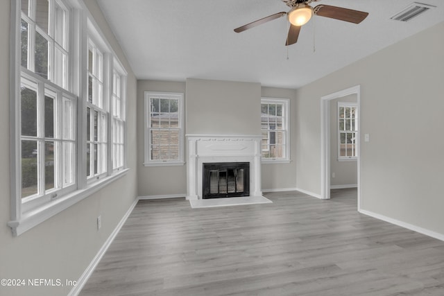 unfurnished living room with ceiling fan and light wood-type flooring