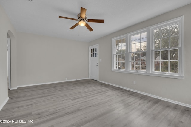 empty room with ceiling fan and light hardwood / wood-style floors