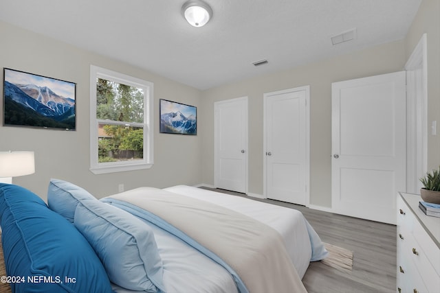 bedroom with a textured ceiling and light hardwood / wood-style flooring