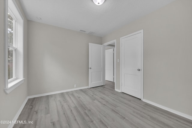 unfurnished bedroom featuring a textured ceiling and light wood-type flooring