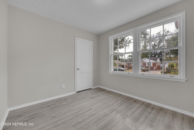 spare room featuring a textured ceiling and light wood-type flooring