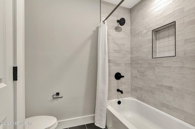 bathroom featuring shower / bath combo with shower curtain, tile patterned flooring, and toilet