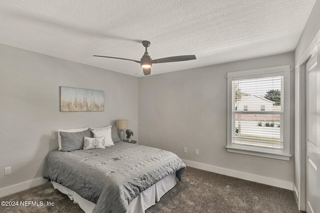 carpeted bedroom featuring ceiling fan and a textured ceiling