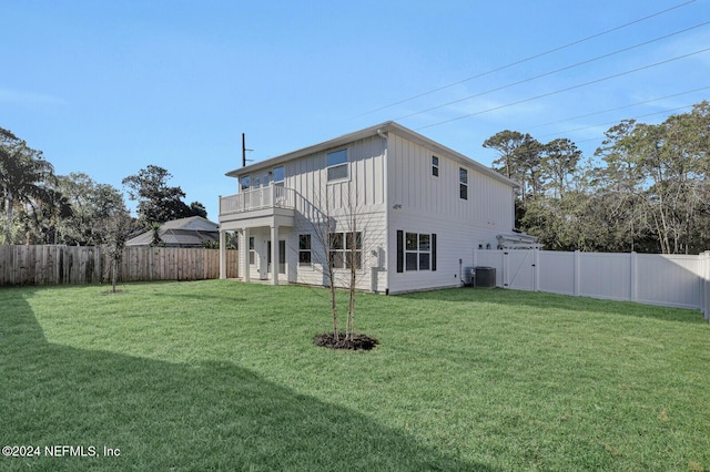 rear view of property featuring a balcony and a lawn