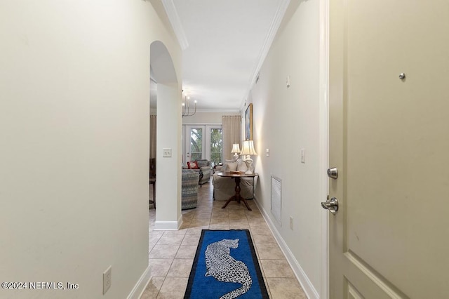 corridor featuring ornamental molding, light tile patterned floors, and french doors