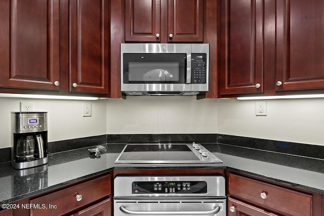 kitchen featuring dark stone countertops and stainless steel appliances