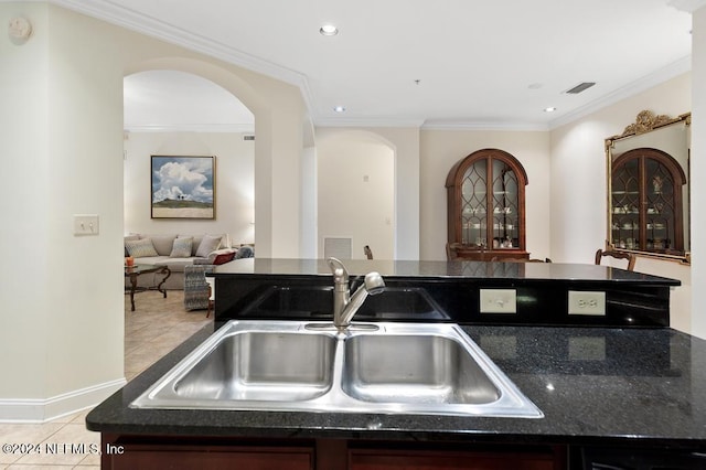 kitchen with crown molding, sink, and light tile patterned floors