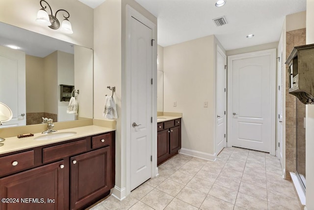 bathroom with tile patterned flooring, vanity, and walk in shower