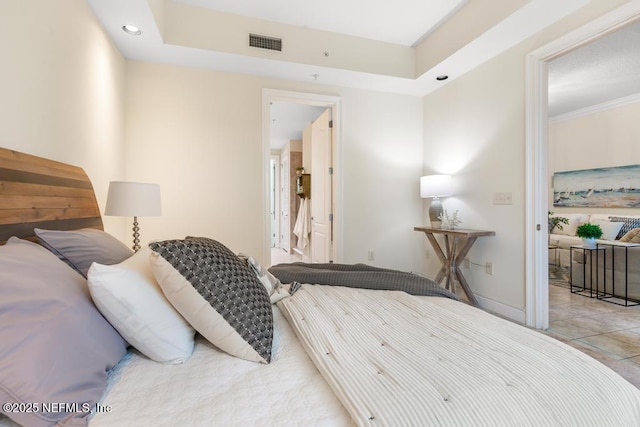 bedroom featuring a tray ceiling and light tile patterned floors