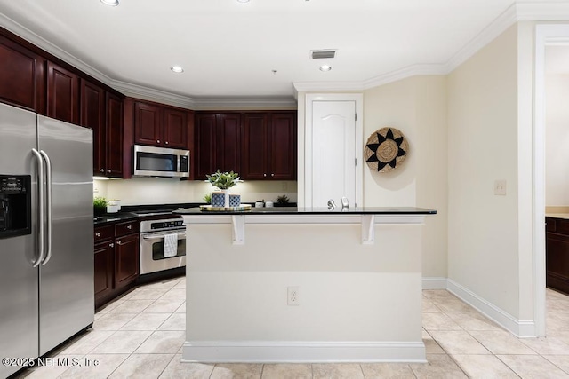 kitchen with a center island with sink, stainless steel appliances, crown molding, a breakfast bar, and light tile patterned floors