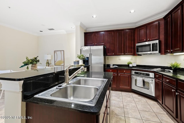 kitchen featuring stainless steel appliances, an island with sink, crown molding, light tile patterned floors, and sink