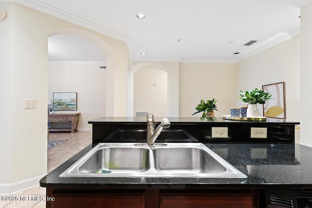 kitchen with crown molding, light tile patterned floors, and sink