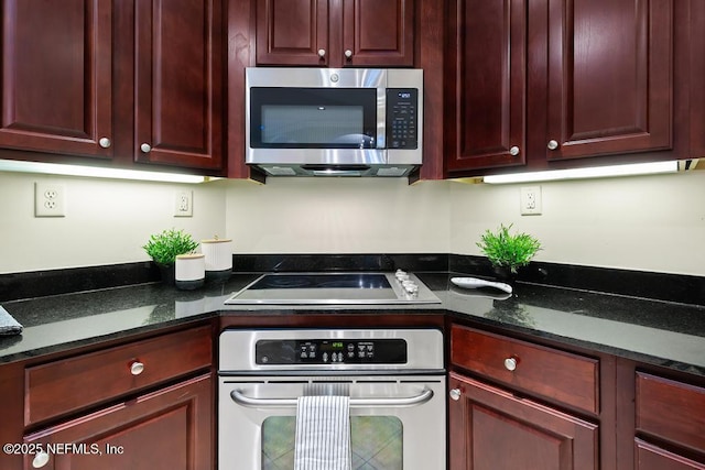 kitchen featuring appliances with stainless steel finishes and dark stone countertops