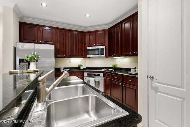 kitchen featuring dark stone countertops, stainless steel appliances, and sink