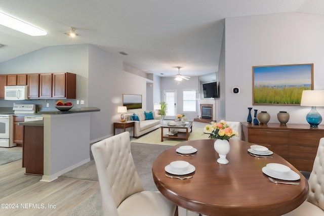 dining area with ceiling fan, light hardwood / wood-style floors, and lofted ceiling