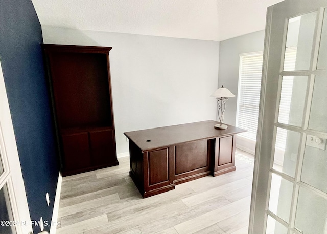 home office featuring a textured ceiling and light hardwood / wood-style flooring