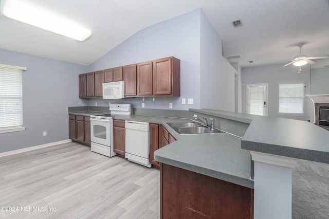 kitchen featuring white appliances, lofted ceiling, sink, light hardwood / wood-style floors, and kitchen peninsula