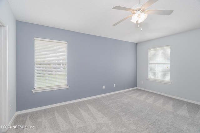 unfurnished room with ceiling fan, carpet floors, and a textured ceiling