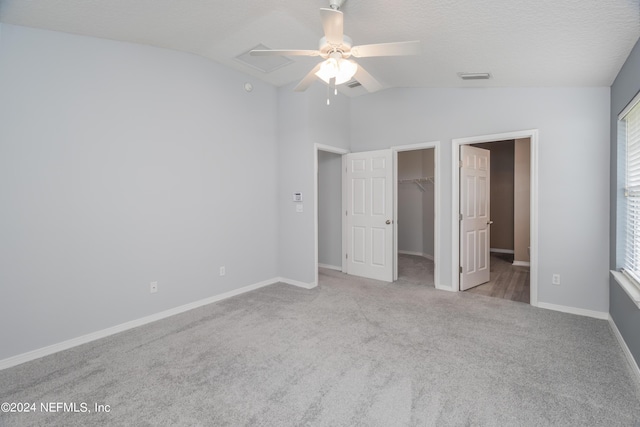 unfurnished bedroom featuring a spacious closet, a closet, ceiling fan, and light carpet