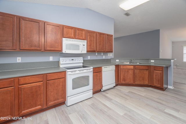 kitchen featuring vaulted ceiling, sink, light hardwood / wood-style floors, and white appliances