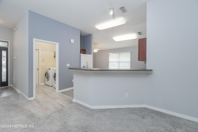 kitchen with kitchen peninsula, ceiling fan, separate washer and dryer, light hardwood / wood-style floors, and white fridge with ice dispenser