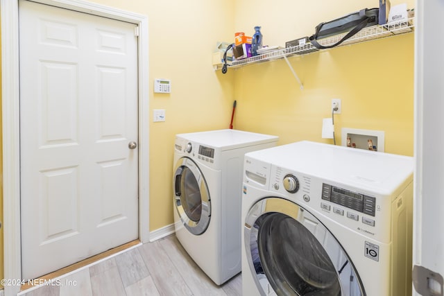 laundry area with separate washer and dryer and light wood-type flooring