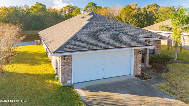 garage with a lawn and a water view