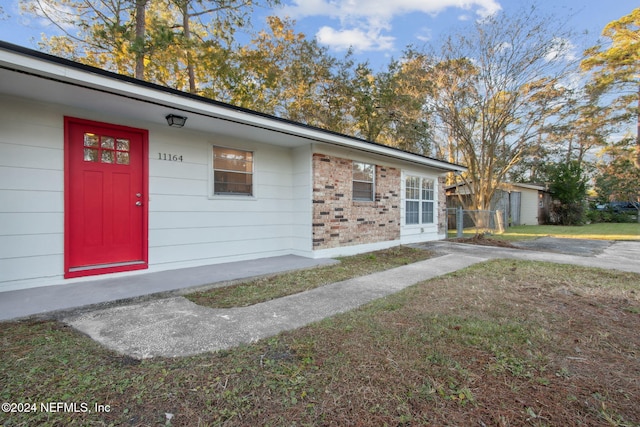 property entrance with a lawn