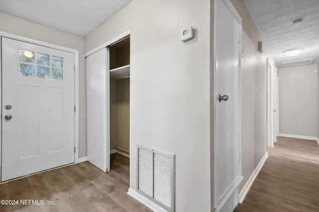 foyer entrance featuring wood-type flooring and a textured ceiling